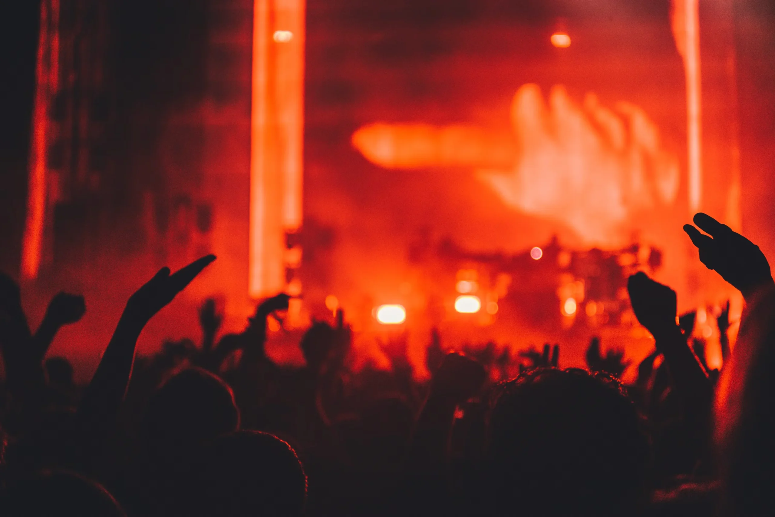 Público frente a un escenario iluminado durante un concierto